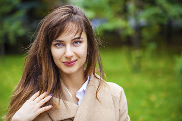 Portrait of a young beautiful woman in beige coat