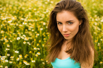 Naklejka premium Photo of pretty brunette woman in chamomile field