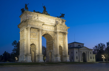 Fototapeta na wymiar Arch of Peace (Arco della Pace) in Sempione Park with Sforza castle in the background, Milan, Italy. Night view.