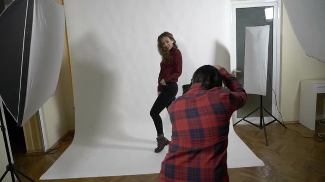 Young attractive fashion model dressed in red striking a pose and flipping her curly blonde hair in slow motion - Powered by Adobe
