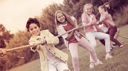 Cheerful children are competing and tug of war