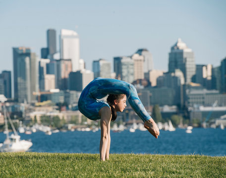 Teenage girl outdoors, balancing on hands in yoga position