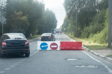 Sign of detour travel. Pit on the road. repair work. cars drive around the work zone
