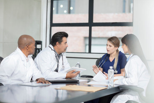 Group of doctors sitting at table, having discussion