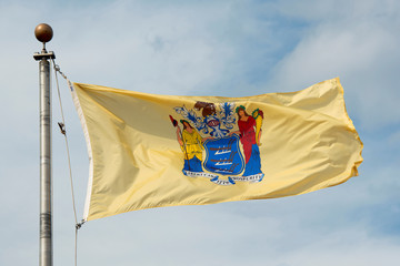Obraz premium Flag of New Jersey in front of New Jersey State House, Trenton, New Jersey, USA.