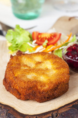 Panierter Camembert mit Salat auf Holz
