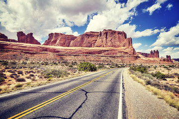 Vintage toned scenic road, travel concept picture, Arches National Park in Utah, USA.