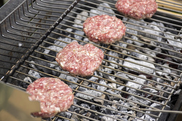 Raw pork and beef meat prepared for hamburgers on barbecue grill treatment