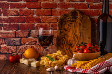 Products for cooking - pasta, tomatoes, garlic, olive oil and red wine.