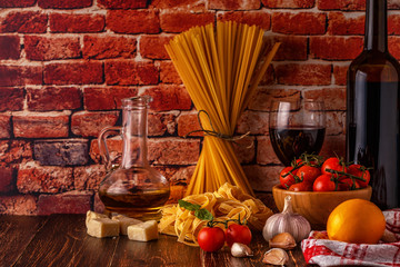 Products for cooking - pasta, tomatoes, garlic, olive oil and red wine.