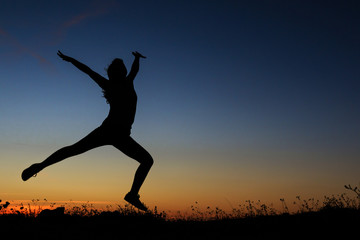 Fototapeta na wymiar Silhouette of a woman jumping happily