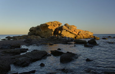 skały oświetlone słońcem na wybrzeżu Rodos (Grecja) - obrazy, fototapety, plakaty