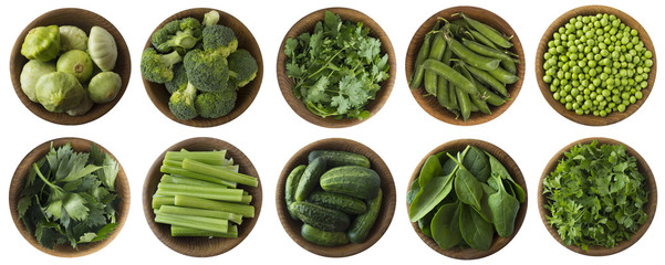 Green vegetables and herbs isolated on a white background. Squash, brocoli, green peas, cucumbers and leaves parsley, celery, cilantro, spinach in wooden bowl with copy space for text. Top view.