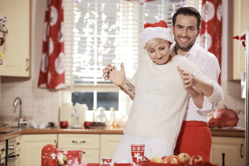 Rodzice / Para w kuchni podczas przygotowań do świąt Bożego Narodzenia - obrazy, fototapety, plakaty