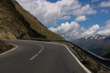 Dangerous panoramic serpentine road high in the Alps between melting snow