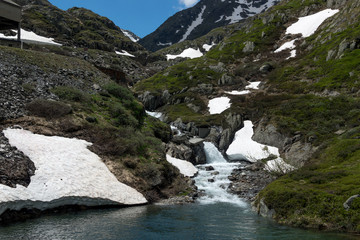 Naklejka na ściany i meble The melting glacier and snow of the mountain peaks in the European Alps during spring