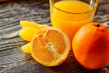 Oranges and orange juice on a wooden background