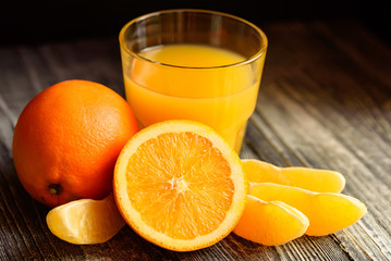 Oranges and orange juice on a wooden background