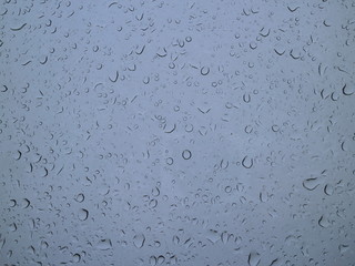 drops of rain on a window in the morning sky