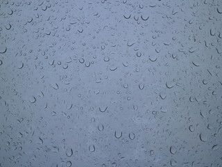 drops of rain on a window in the morning sky