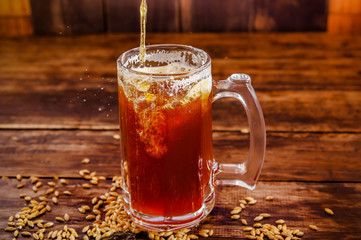 Indoor view of glass of beer with wheat in the base on a wooden table on a dark pub
