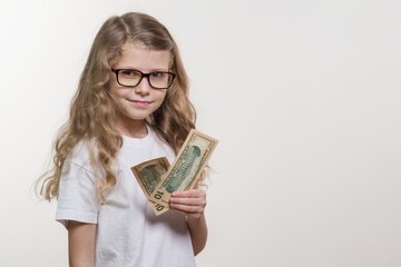 Smiling little girl with cash, white background, copy space. Money, Finance and the Concept of People