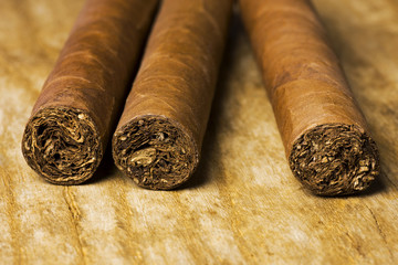 Set of Cuban cigars lying on an old wooden board