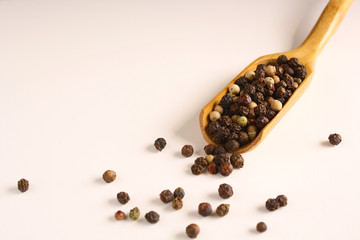 Pepper peas white black red in a wooden spoon