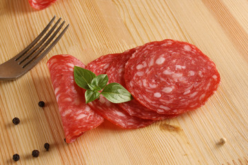 Spain sausage Salchichon Slicing salami Wooden background