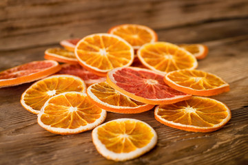 Stack of dried orange and grapefruit slices on old wooden table, christmas style