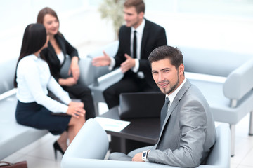 businessman sitting in an office on the background of business team.