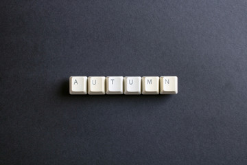 Autumn word is written with computer keys button on a dark background.