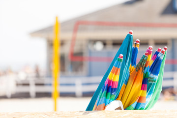 Closed sun umbrellas on sandy beach