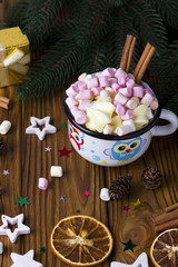 Christmas background star, cup marshmellow cinnamon brown wooden table.