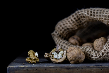 Peanuts in a natural bag. A sack of nuts on an old dark wooden table.