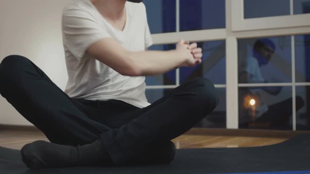 Man makes an exercise for abdominal muscles sitting on floor