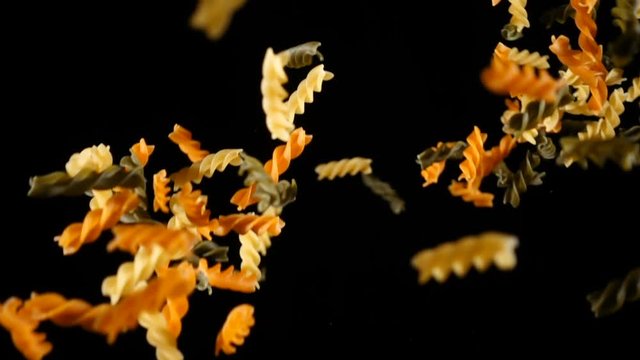 Falling pile of colorful pasta, slow motion