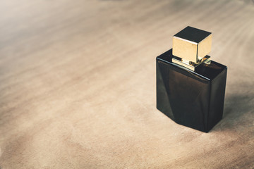 Black perfume on a wood background.