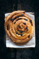 Baked pastry with dried grapes on wooden background,selective focus