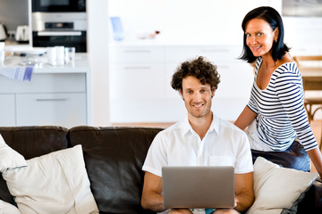Couple at home using laptop
