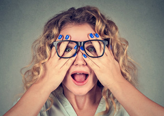 Closeup portrait young woman in glasses covering face eyes with both hands isolated on gray wall background