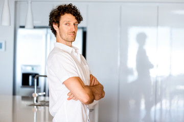 Portrait of a smart young man standing in kitchen