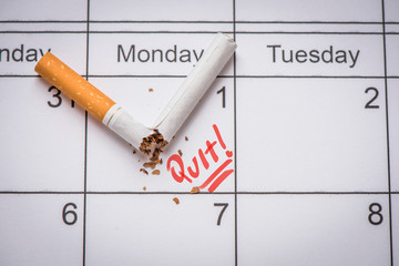 Broken cigarette on calendar. Time to quit smoking concept