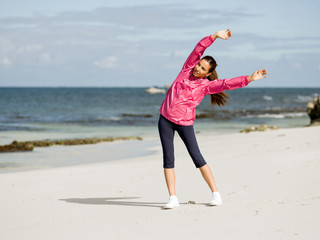 Young woman at the beach doing exercises