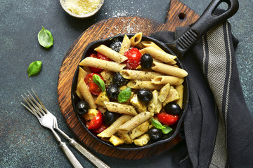 Whole grain pasta with tomato cherry,black olives and chicken.Top view with copy space.