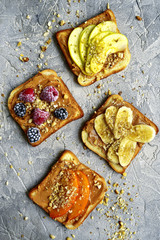 Toasts with peanut butter,nuts and fruits.Top view.