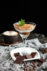 beautiful serving of tiramisu in a glass cup with a cup of coffee with marshmallow