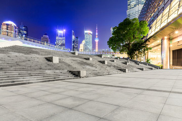 Fototapeta na wymiar Empty square floor and modern cityscape at night in Shanghai,China