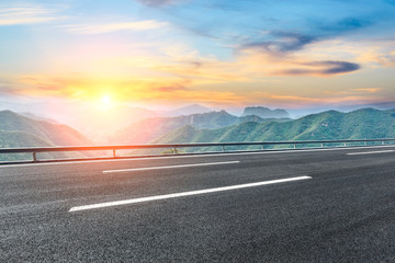 Fototapeta premium Asphalt highway and mountain nature landscape at sunset