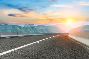 Asphalt highway and mountain nature landscape at sunset